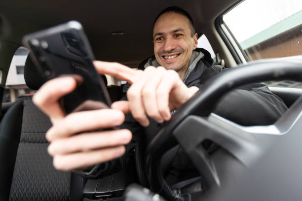 istock Success in motion. Handsome young man in full suit smiling while driving a car 1530786365