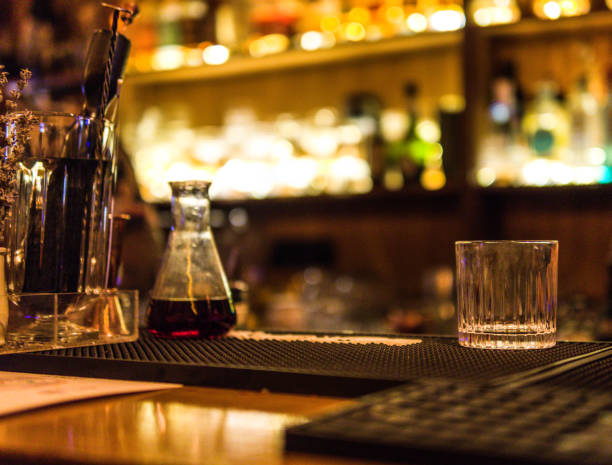 istock a negroni exclusive preparation | an alchemy container with a delicious alcoholic drink and an empty glass in a bar 1530787944
