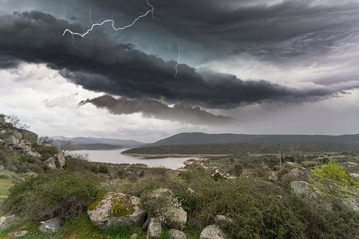 Spectacular green landscape in the town of Berrueco with the Atazar reservoir in the background and an impressive storm in the sky.