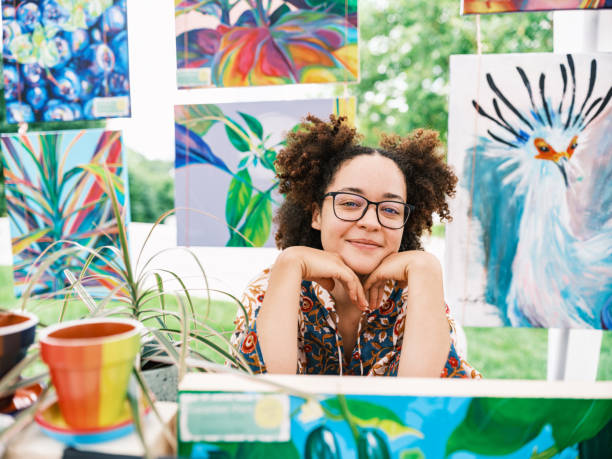 Young Latin woman artist selling her art at Outdoor Market stock photo