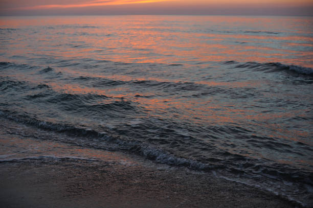 istock Beautiful sunset over ocean in golden hour with clouds and waves 1530809424