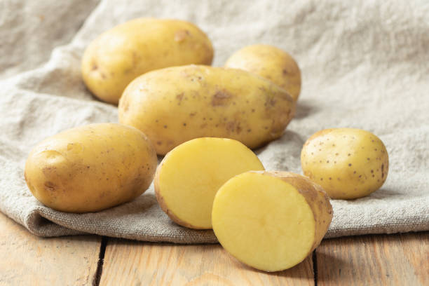 istock Ripe potato tuber cut in half on coarse burlap fabric. 1530815682