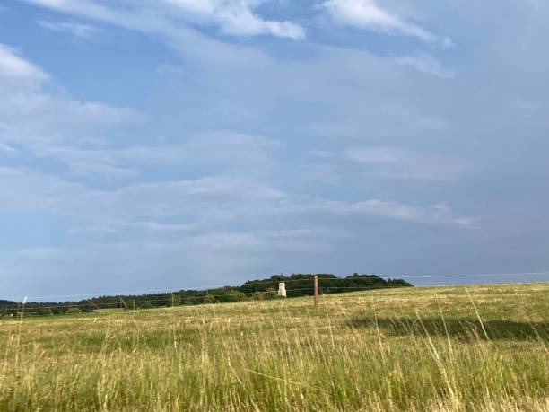 istock Rural landscape scene featuring an expansive green meadow with a white lighthouse in the background 1530816879