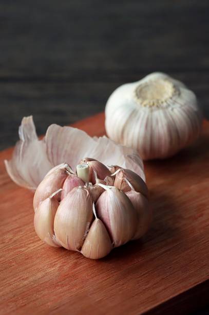istock Fresh garlic cloves on a wooden cutting board 1530819856