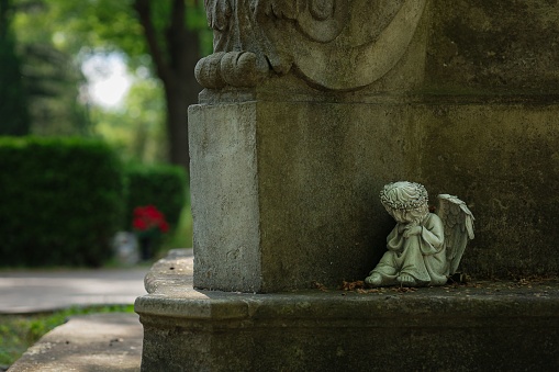 A small angel statue on a gravestone in the cemetery. Poznan, Poland.
