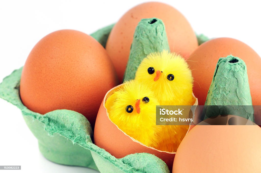 beige huevos con dos jóvenes verde con pollo en una caja de cartón - Foto de stock de Alimento libre de derechos