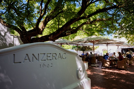 Stellenbosch, South Africa – January 25, 2023: The outdoor restaurant at Lanzerac Hotel shaded by a green tree. Stellenbosch, South Africa.