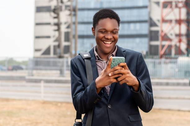 istock Young African using a smartphone with a bright smile on his face. 1530852158