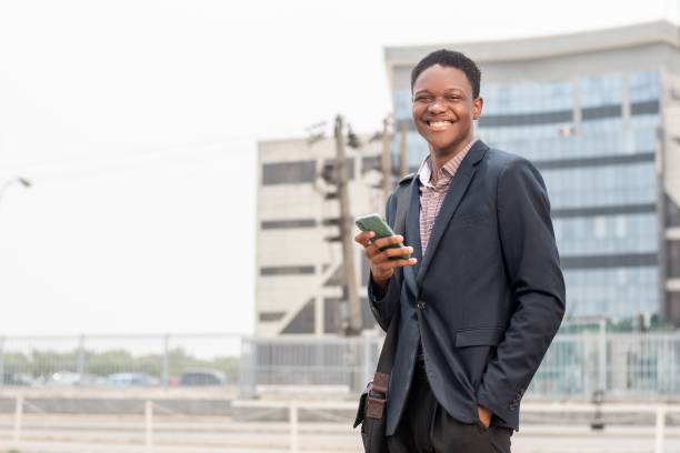 istock Young cheerful African man with a phone in an outdoor setting. 1530852162