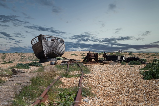 An old wooden boat abandoned on a gloomy seaside beach