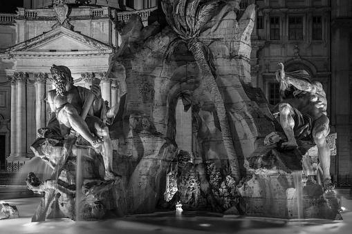 A grayscale shot of a historic sculpture in the Piazza Navona in Rome, Italy