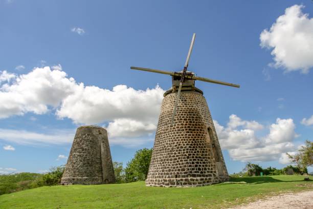 istock Landscape view of two rustic, brick windmills in a green field 1530861307
