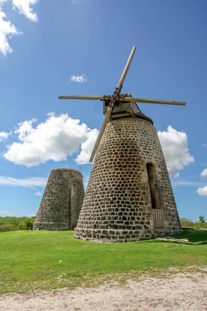 istock Vertical view of two rustic, brick windmills in a green field 1530861310