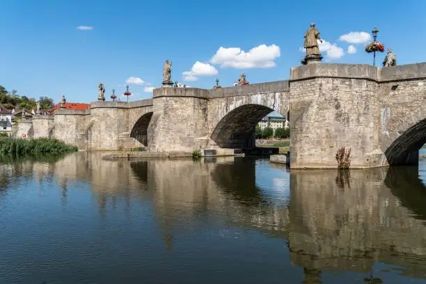 A beautiful stone bridge with ornamental statues spanning a river in Wurzburg, Bavaria, Germany.