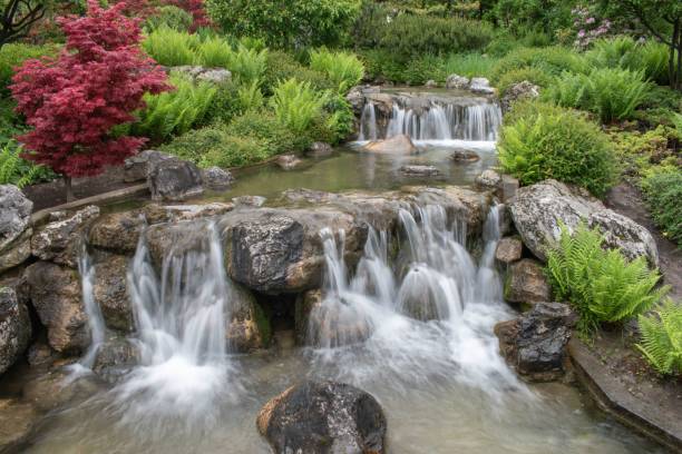 istock Tranquil scene of a waterfall in a lush garden. 1530877378