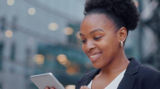 istock Happy african american businessman using tablet device while standing near big office windows outdoors. Man scrolling pages, tapping on touchscreen, checking financial charts. close up. 1530883060
