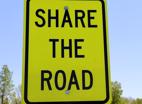 A close view of the yellow share the road sign.