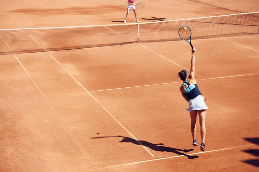 Top view image of professional tennis player in motion, young woman during game, training at open air stadium, court. Concept of sport, hobby, active lifestyle, health, endurance and strength, ad