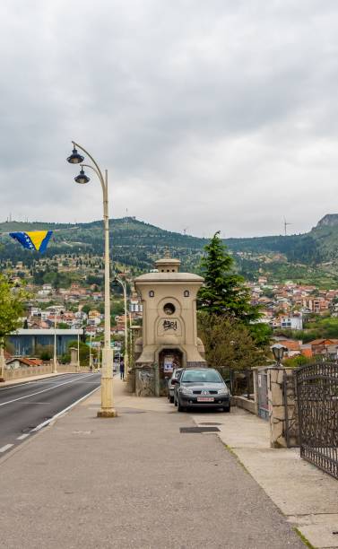 uma longa rua com uma cerca ao lado de uma estrada com dois carros passando por ela - tranquil scene sky street road - fotografias e filmes do acervo