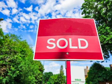 A sold sign outside a house on a residential street that has just been sold.