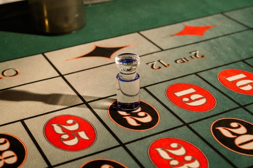 A high-angle close-up shot of a roulette wheel with a chip