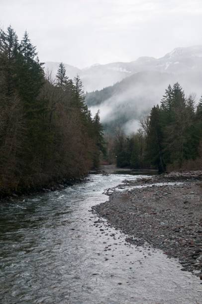 istock River snaking through a picturesque winter scene, with snow-dusted trees and snow-covered riverbanks 1530919431