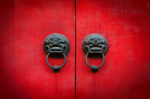 Old chinese red door with lion head metal knockers