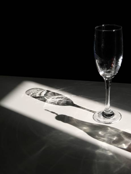 istock Crystal clear, empty wine glass sits on a white table, illuminated by a beam of natural sunlight 1530927477