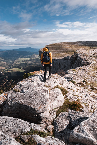 young mountaineer man walks on the rocks through the spectacular landscape of the mountains of gorobel or sierra salbada in Alava Basque Country