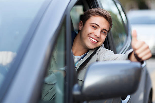 istock Young man doing thumps-up in car 153092870