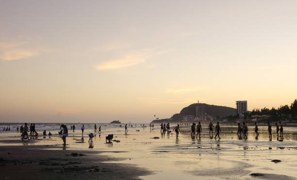 istock People playing on the beach at sunset 1530931584