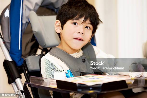 Foto de Quatro Ano De Idade Menino Com Deficiência Estudando Em Cadeira De Rodas Ou De Leitura e mais fotos de stock de Criança