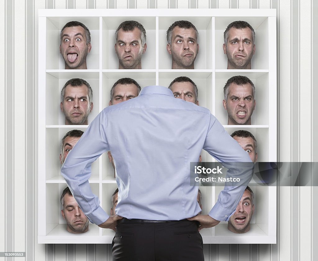 Confused Conceptual image of young businessman choosing which face expression to wear Adult Stock Photo