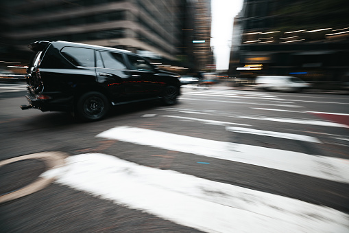 A blurred car crossing a road intersection in New York. Panning effect.