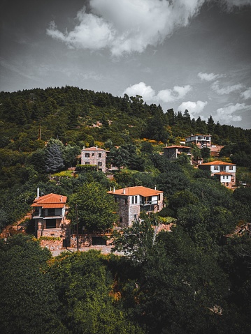 A picturesque view of several hillside homes tucked away under a cloudy sky