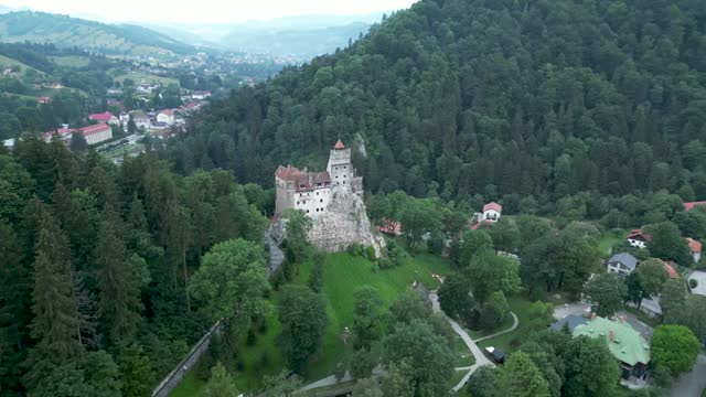 Drone view over the Bran Castle surrounded by green vegetation
