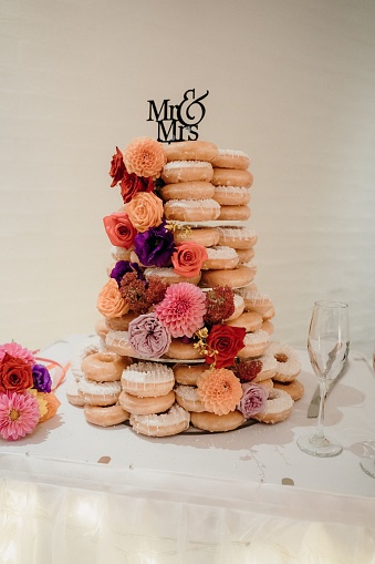 A wedding cake featuring a classic donut design adorned with a 'Mr & Mrs' sign
