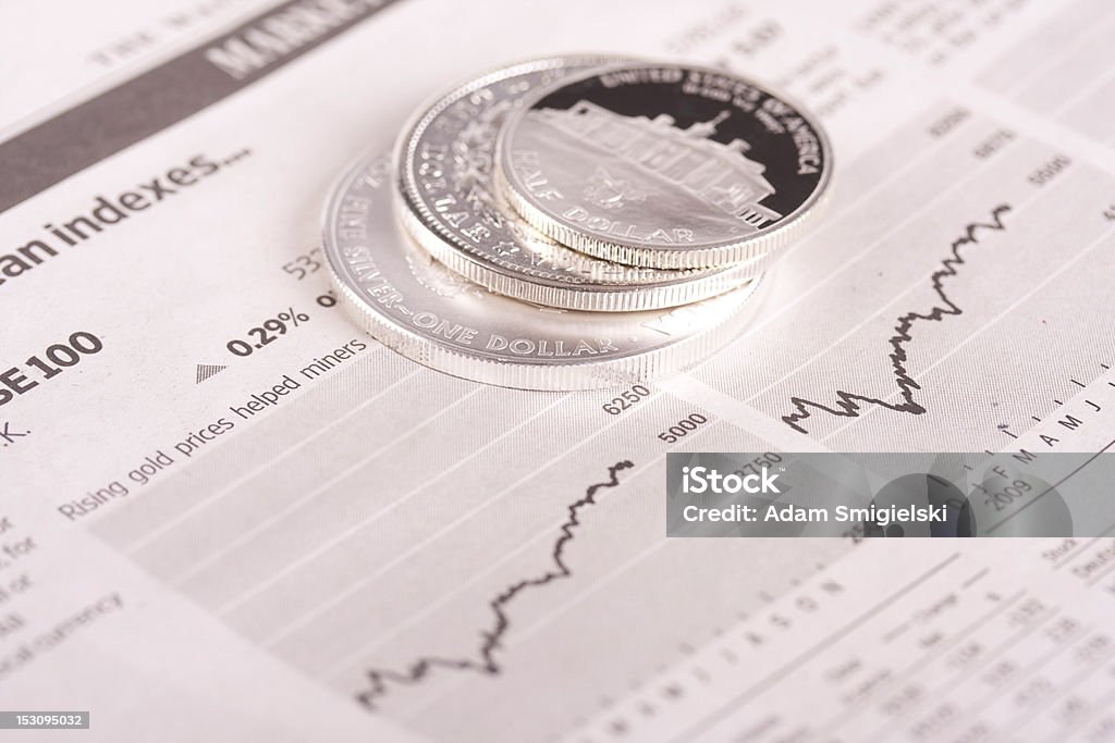 dollar coins on financial newspaper silver dollar coins on top of financial newspaper Adversity Stock Photo