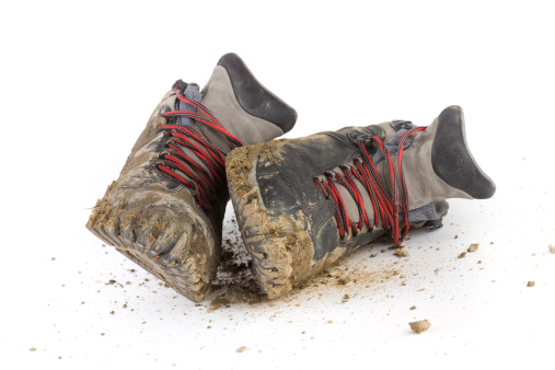 a pair of muddy grey/black hiking shoes on white background