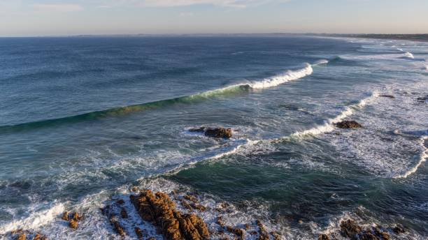 istock the waves come to shore in front of a cliff and sky 1530956459