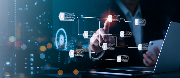 The blockchain technology concept is illustrated using a chain diagram and encrypted blocks. A businessman's hand is clutching a tablet computer, a social media diagram, and a business plan.