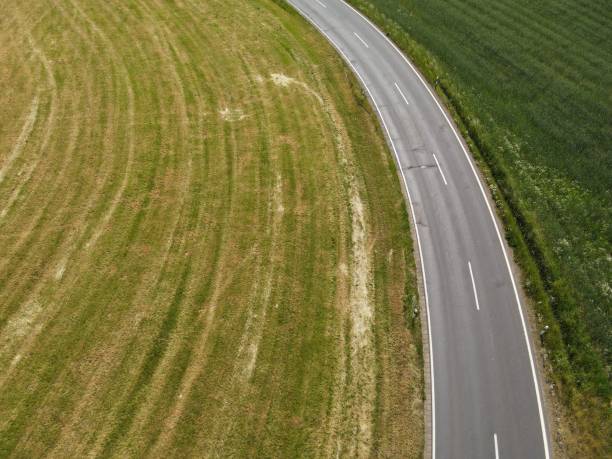 istock Drone view of a curved asphalt road between grass fields in the landscape 1530976162