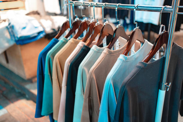 Multiple T-shirts hung on display at a roadside clothing vendor during the night.