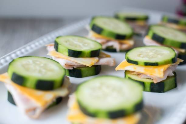 istock White plate decorated with turkey, cheese, and cucumber-bite sandwiches. 1530993279