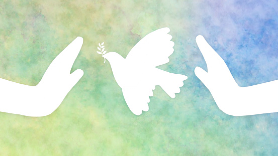 Paper hands release the dove of Peace into the sky blue watercolor background. International Day of Peace