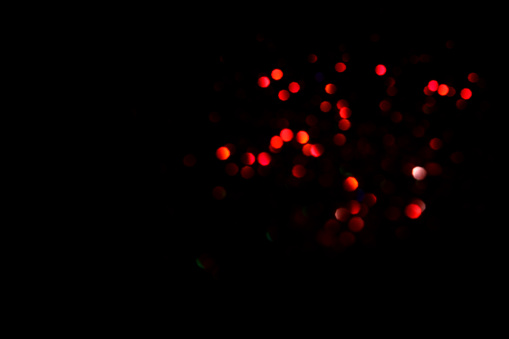 Red blurred bokeh lights on black background. Glitter sparkle confetti for celebrate. Overlay for your design