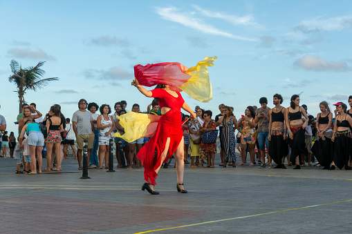 Salvador, Bahia, Brazil - October 22, 2022: People are seen during a street artist's dance performance at Farol da Barra, in Salvador, Bahia.