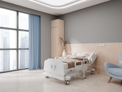 Interior of stylish private hospital ward with light gray and wooden walls, tiled floor, comfortable bed with brown blanket and cozy blue armchair. 3d rendering