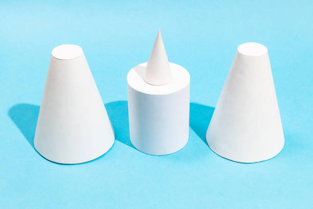 handmade various paper cones and cylinder on turquoise blue background
