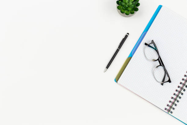 istock Notepad, glasses and pen on a white background, top view. 1531103014